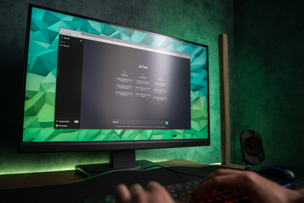 User interacting with AI chatbot interface on a desktop monitor in a modern workspace